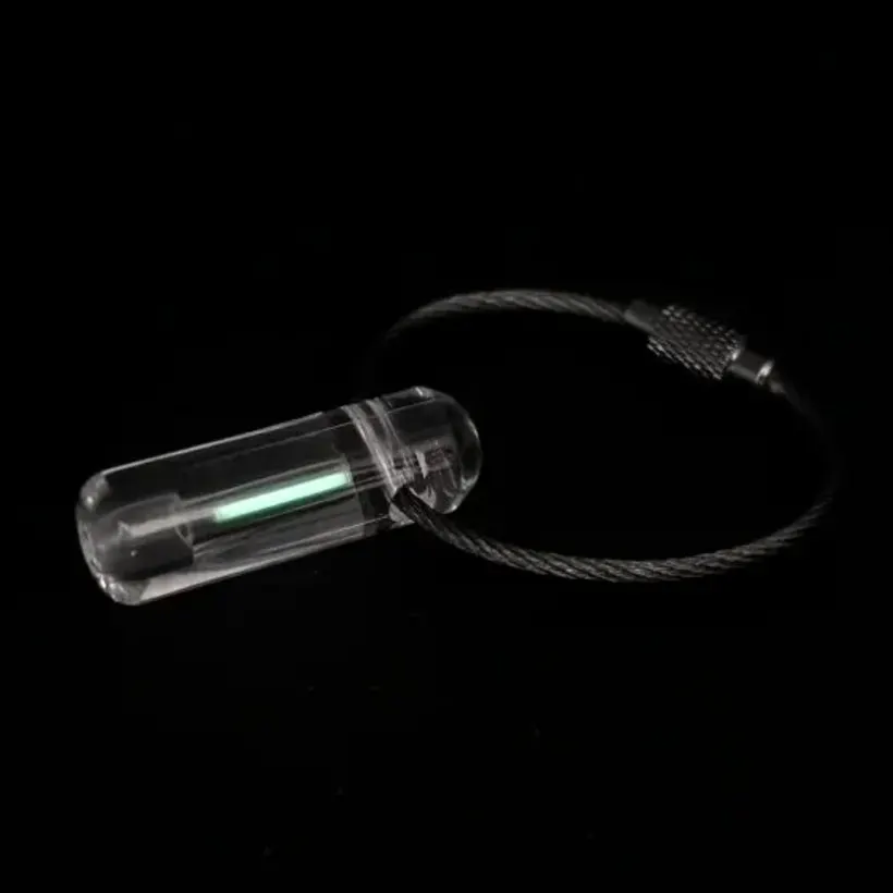 Tritium Markör LitenX: en klar kapsel med en grön tritiumljuskälla på en nyckelring av wire med skruvlås.